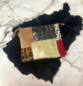 Stenciled multi-print genuine cowhide patchwork clutch on black fur background